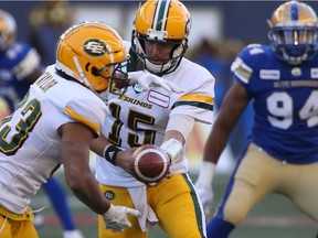 Edmonton Eskimos quarterback Logan Kilgore (15)l hands the ball off to Alex Taylor (33) during CFL action against the Winnipeg Blue Bombers in Winnipeg on Friday, May 31, 2019.