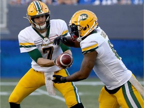 Edmonton Eskimos quarterback Trevor Harris, left, hands off to running back C.J. Gable during CFL action against the Blue Bombers in Winnipeg on Thursday, June 27, 2019.