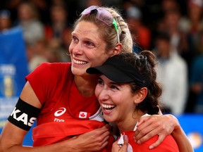 Sarah Pavan, left, and Melissa Humana-Paredes of Canada celebrate after winning the gold medal match against April Ross of United States and Alix Klineman on day nine of the FIVB Beach Volleyball World Championships Hamburg 2019 at Rothenbaum Stadion  on July 06, 2019, in Hamburg, Germany.