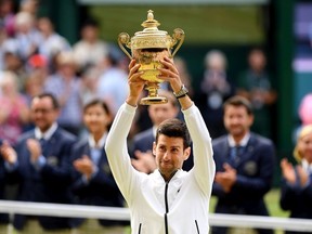 Novak Djokovic of Serbia lifts the trophy after winning his Men's Singles final against Roger Federer of Switzerland during Day thirteen of The Championships - Wimbledon 2019 at All England Lawn Tennis and Croquet Club on July 14, 2019 in London, England.