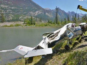 The wreckage of a Cessna 150J that crashed into the Athabasca River east of Jasper on Sunday is recovered by the Transportation Safety Board of Canada. The crash left one dead and one seriously injured.