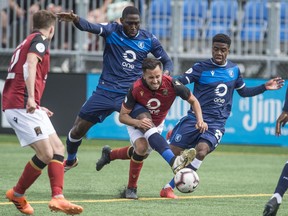 James Marcello of FC Edmonton, challenges Dylan Carreiro of Valour FC at Clarke Field in Edmonton on June 2, 2019.