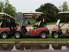 Golf carts are seen parked next to a puddle after a rainstorm at Highlands Golf Club in Edmonton, on Thursday, June 27, 2019. Photo by Ian Kucerak/Postmedia