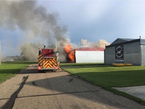Fire crews battle a blaze that broke out in a private hanger at the Lacombe Regional Airport on the evening of July 7, 2019. The fire destroyed three small planes.