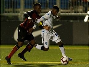 FC Edmonton's Bruno Zebie (20) battles Valour FC's Raphael Ohin (27) during the second half of a Canadian Premier League soccer game after a thunderstorm delay at Clarke Stadium in Edmonton, on Wednesday, July 17, 2019.