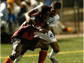FC Edmonton's Ajay Khabra (23) battles Valour FC's Raphael Ohin (27) during the second half of a Canadian Premier League soccer action after a thunderstorm delay at Clarke Stadium in Edmonton, on Wednesday, July 17, 2019.