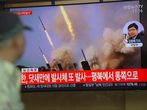 People watch a television news programme showing file footage of North Korea's projectile weapons, at a railway station in Seoul on May 9, 2019.