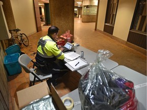 A peace officer sits at a reception table Feb. 6, 2019 when Central LRT station opened as a temporary shelter for the homeless during a blast of cold weather.