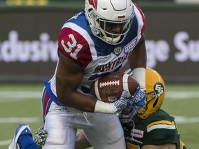 Edmonton Eskimos J.C. Sherritt (47) wraps up Montreal Alouettes running back William Stanback (31) during first half CFL action in Edmonton on August 18, 2018.