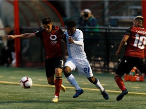 FC Edmonton's Bruno Zebie (20) battles Valour FC's Dylan Sacramento (7) and Dylan Carreiro (10) during Canadian Premier League soccer action after a rain delay at Clarke Stadium in Edmonton, on Wednesday, July 17, 2019.