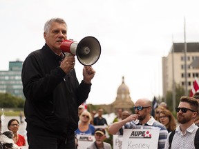 Alberta Union of Provincial Employees (AUPE) president Guy Smith speaks to members and supporters as they march from Capital Plaza near the Alberta Legislature to Jasper Ave while protesting Bill 9 in Edmonton, on Wednesday, July 31, 2019. Photo by Ian Kucerak/Postmedia