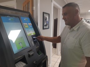 Bill Eaton puts his Easy Cash transaction kiosk through its paces. Photo by GRAHAM HICKS / EDMONTON SUN