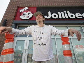 Jordan Haworth poses for a photo outside the new Jollibee restaurant, 3803 Calgary Trail, in Edmonton Wednesday Aug. 14, 2019. The restaurant opens Friday, but Haworth has been camped outside of the store since 9 am Tuesday. About a dozen other people have joined him in line since Haworth set up camp. Photo by David Bloom