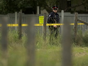A police officer guards a scene near Callingwood Road and Anthony Henday Drive in Edmonton on Saturday, Aug. 17, 2019.
