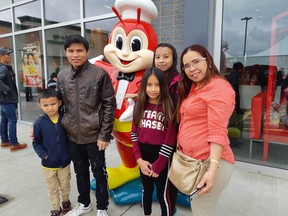 The Valdez family from Leduc waited in a three-hour lineup to eat at the new Jollibee: Left to right, Nathan, 9; dad Ray; The Jollibee mascot, Maechiel, 12; Reychelle, 15; mom Ritchiel. Photos by GRAHAM HICKS / EDMONTON SUN