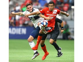Whitecaps Jake Nerwinski (L) and Cavalry FC Jose Escalante battle for the ball during third round CPL Canadian Championships soccer action between Cavalry FC and Vancouver Whitecaps at BC Place in Vancouver, BC Wednesday, July 24, 2019. Jim Wells/Postmedia