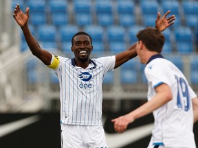 FC Edmonton's Easton Ongaro (19) celebrates a goal with Tomi Ameobi (18) on HFX Wanderers FC's goalkeeper Christian Oxner (50)  during the first half of a Canadian Premier League soccer game at Clarke Stadium in Edmonton, on Wednesday, July 31, 2019.