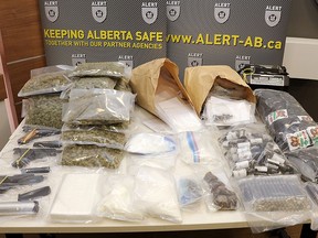 Three stolen handguns and more than $560,000 worth of drugs and cash have been seized after ALERT searched two Edmonton homes.(Supplied photo/ALERT)