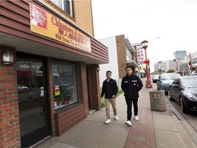 Pedestrians walk along 97 Street in Chinatown on Monday, Aug. 19, 2019.