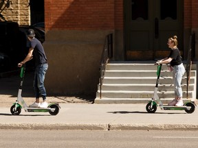 Two riders try out Lime electric scooters along 101 Street in Edmonton, on Wednesday, Aug. 21, 2019. The scooters were recently approved for use in the city. Photo by Ian Kucerak/Postmedia