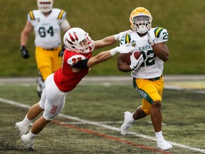 University of Alberta Golden Bears' Jonathan Rosery (22) is tackled by Calgary Dinos' Joe Cant (27) during the U of A's home opener at Foote Field in Edmonton, on Friday, Aug. 30, 2019. Photo by Ian Kucerak/Postmedia