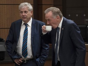 NDP MP Charlie Angus and Conservative MP Peter Kent wait for the House of Commons on Access to Information, Privacy and Ethics Committee to begin on Parliament Hill in Ottawa, Wednesday Aug. 21, 2019.