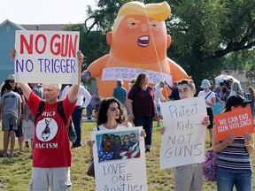 Protesters gather around a baby Trump balloon to voice their rally against gun violence and a visit from U.S. President Donald Trump following a mass shooting in Dayton, Ohio, Aug. 7, 2019.