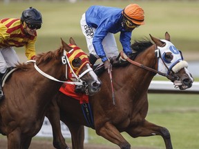 Journeyman ridden by Dane Nelson, right, pulls ahead of Explode ridden by Amadeo Perez for the win at the Canadian Derby at the Century Mile, in Edmonton Alberta, August 18, 2019.