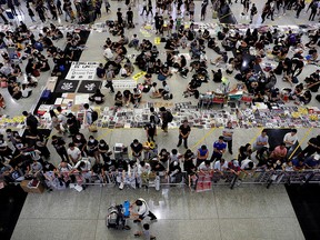 Anti-Extradition bill protesters distribute leaflets to passengers during a mass demonstration at the Hong Kong international airport, in Hong Kong, China, Aug. 13, 2019.