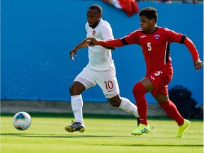 Cuba defender Daniel Morejon (5) tries to cover Canada forward Junior Hoilett (10) during group play in the CONCACAF Gold Cup soccer tournament at Bank of America Stadium.