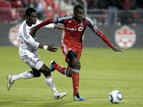 Tony Tchani of Toronto FC gets by Gershon Koffie of Vancouver Whitecaps during the first half of action of the Canadian soccer championship at BMO Field in Toronto, 2011.