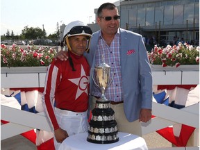 Jockey Orlando Mojica (left) and trainer Robertino Diodoro pose with the trophy after Mojica rode Oil Money to victory in the Manitoba Derby at Assiniboia Downs on Mon., Aug. 5, 2019.