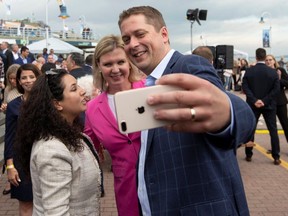 Conservative Leader Andrew Scheer and his wife, Jill (in pink), take a selfie with a supporter as he launches his election campaign in Trois-Rivieres, Que., on Sept. 11, 2019. (REUTERS)