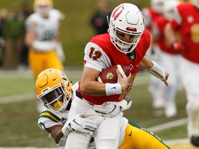 University of Alberta Golden Bears' Shaydon Philip (11) sacks Calgary Dinos' quarterback Adam Sinagra (12) during the U of A's home opener at Foote Field in Edmonton, on Friday, Aug. 30, 2019.