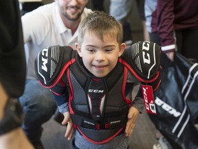 Lincoln McLean, 6, gets his first pair of shoulder pads and can't control his excitement on September 14, 2019. Hockey Education Reaching Out Society (HEROS) is a charity that uses hockey to teach life-skills and empower marginalized youth. They teamed up with Children's Autism Services of Edmonton to help a group of children with autism enjoy the benefits that playing hockey can bring. Photo by Shaughn Butts / Postmedia