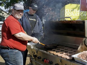 Volunteers cook burgers on the grill at the Edmonton and District Labour Council's annual Labour Day barbecue held at Giovanni Caboto Park in Edmonton on Monday Sept. 2, 2019.
