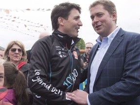 Prime Minister Justin Trudeau, left, shakes hand with Conservative Leader Andrew Scheer at the start of the Defi Pierre Lavoie, a 1000-km bicycle trek, Thursday, June 14, 2018 in Saguenay Que. THE CANADIAN PRESS/Jacques Boissinot
