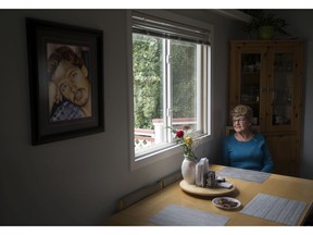 Jane Orydzuk, Victims of Homicide Support Society president and founder, sits at her kitchen table while speaking to a reporter, in Edmonton Friday Sept. 6, 2019. A portrait of her son Tim Orydzuk is visible on the wall nearby. Tim Orydzuk was murdered Oct. 1, 1994. Photo by David Bloom