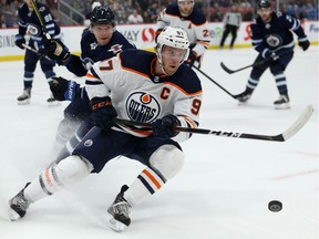 Edmonton Oilers centre Connor McDavid (right) cuts behind Winnipeg Jets defenceman Dmitry Kulikov during NHL pre-season action at Bell MTS Place in Winnipeg on Thurs., Sept. 26, 2019.