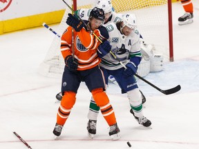 Edmonton Oilers' Connor McDavid (97) battles Vancouver Canucks' Christopher Tanev (8) during second period NHL action at Rogers Place in Edmonton, on Wednesday, Oct. 2, 2019.