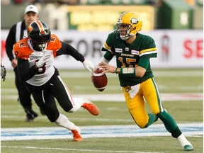 Edmonton Eskimos quarterback Logan Kilgore (15) runs the ball past BC Lions' Jonathan Newsome (8) during first half CFL action at Commonwealth Stadium in Edmonton, on Saturday, Oct. 12, 2019.