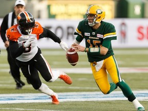 Edmonton Eskimos' quarterback Logan Kilgore (15) runs the ball past BC Lions' Jonathan Newsome (8) during first half CFL action at Commonwealth Stadium in Edmonton, on Saturday, Oct. 12, 2019.
