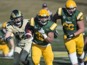 Bears runningback Mathew Peterson scrambles for a few yards in the first half. The University of Alberta Golden Bears were defeated by the Regina Rams 31-17 at Foote Field on Saturday, Oct. 19, 2019.
