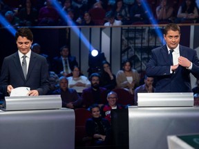 (FILES) In this file photo taken on October 10, 2019 Canada's Prime Minister and Liberal leader Justin Trudeau (L) and Conservative leader Andrew Scheer take part in the Federal leaders French language debate at the Canadian Museum of History in Gatineau, Quebec. - The gloves have come off as Justin Trudeau struggles to hold onto his parliamentary majority heading into the last week of a tight campaign before Canada's October 21 general election. The latest polls put his Liberals in a dead heat with the Conservatives, led by Andrew Scheer. (Photo by Adrian Wyld / POOL / AFP)