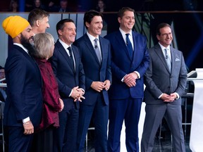 In this photo taken on October 10, 201, federal party leaders (from left) NDP leader Jagmeet Singh, Green Party leader Elizabeth May, People's Party of Canada leader Maxime Bernier, host Patrice Roy from Radio, Canada's Prime Minister and Liberal leader Justin Trudeau, Conservative leader Andrew Scheer, and Bloc Quebecois leader Yves-Francois Blanchet pose for pictures before the Federal leaders French language debate at the Canadian Museum of History in Gatineau, Quebec.(ADRIAN WYLD/POOL/AFP via Getty Images)