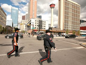 Calgary Police Sgt Chris Ogwal (L) and Cst Steve Ross walk the downtown beat in and around the downtown core in Calgary on Tuesday, September 24, 2019. As well as patrolling Central Park, they checked out known drug hang outs, hiding spots and various complaints while out on foot, including a possible car break-in and a 911 call. Jim Wells/Postmedia
