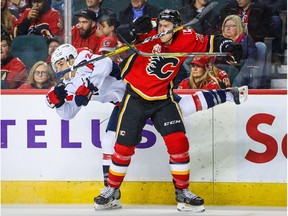 Calgary Flames defenseman Michael Stone (26) and Washington Capitals right wing Garnet Hathaway (21) collide during the second period at Scotiabank Saddledome.