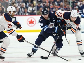 Edmonton Oilers defenceman Darnell Nurse (25) and Edmonton Oilers forward Leon Draisaitl (29) check Winnipeg Jets forward Blake Wheeler (26) during the second period at Bell MTS Place.