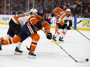 The Edmonton Oilers' Connor McDavid (97) battles past the Philadelphia Flyers Justin Braun (61) to score during second period NHL action at Rogers Place, in Edmonton Wednesday Oct. 16, 2019.