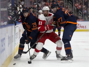 The Edmonton Oilers' Leon Draisaitl (29) and Oscar Klefbom (77) battle the Detroit Red Wings' Luke Glendening (41) during first period NHL action at Rogers Place, in Edmonton on Friday, Oct. 18, 2019.